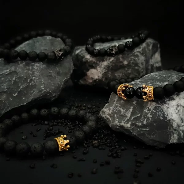 czarne bransoletki męskie leżące na kamieniach